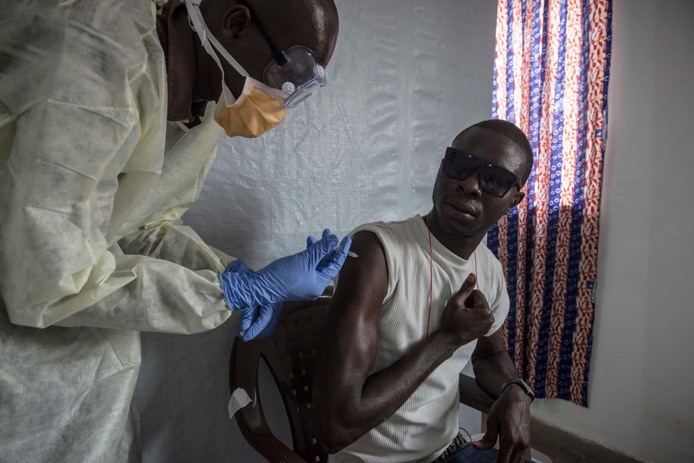 Dobrovolník z řad pracovníků v přední linii boje proti ebole dostává vakcínu na klinice v nemocnici Donka v guinejském Konakry.